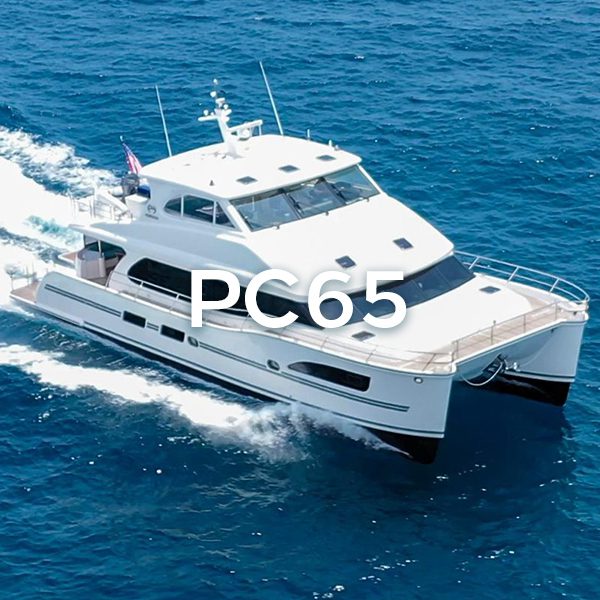 White PC65 catamaran yacht on water.