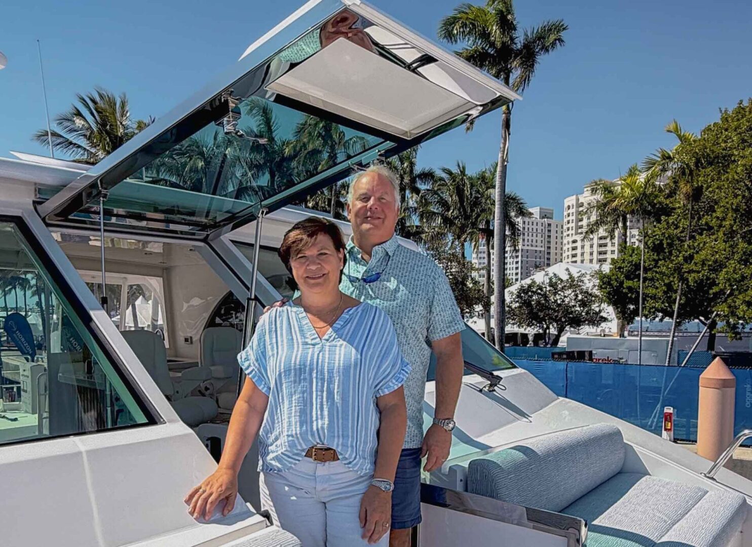 Couple posing proudly on their new yacht.