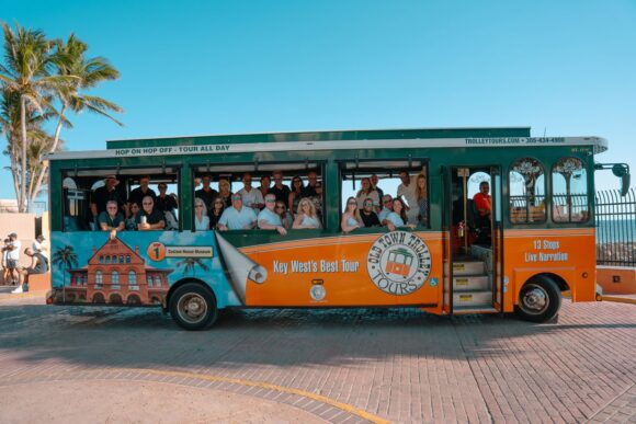 Tourists on an orange sightseeing trolley bus.