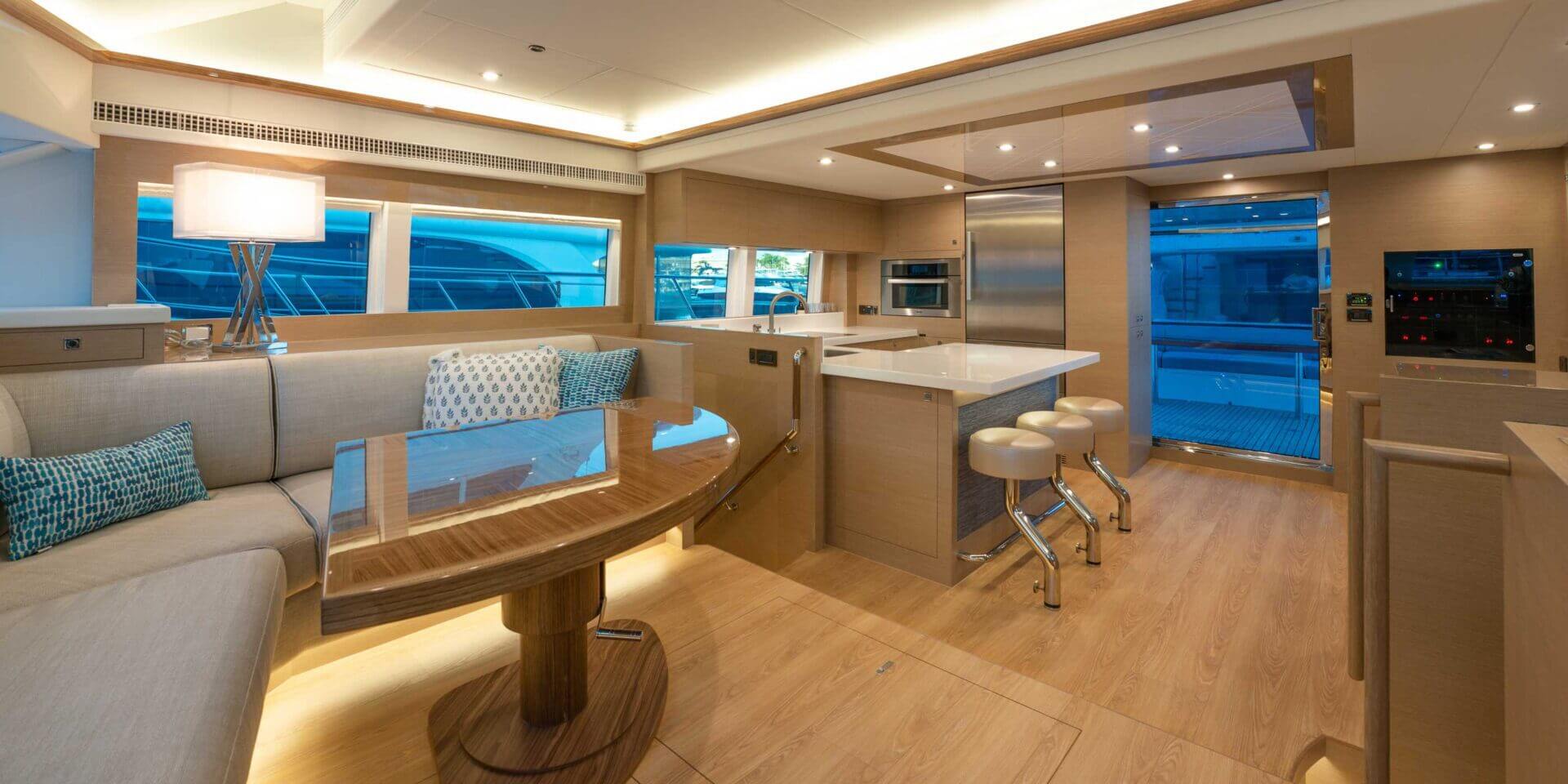 Luxury yacht interior with modern kitchen and seating.